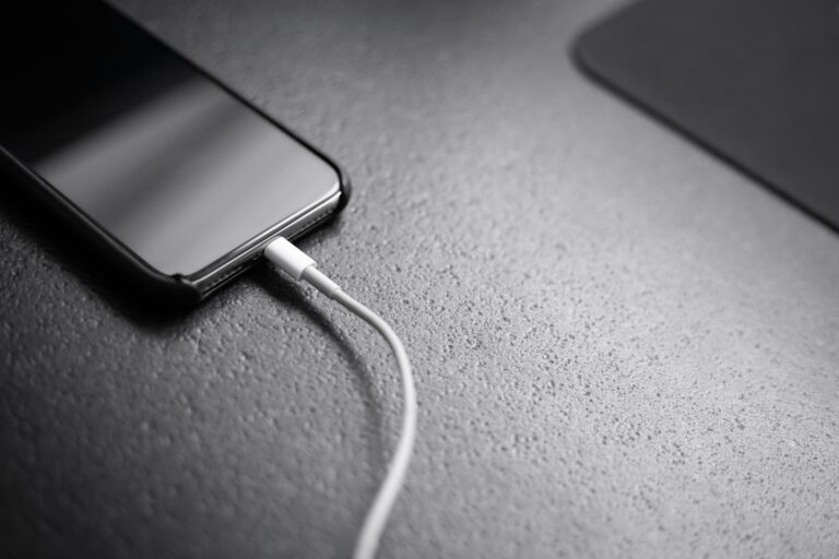 A smartphone plugged into a charging cable, illustrating the battery capacity gap between U.S. and Chinese Android phones