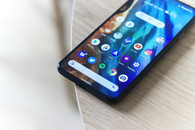 Black Android smartphone lying on a wooden table, illustrating Google's developer verification rules for sideloaded apps