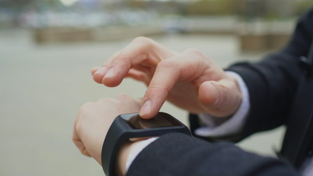 Close-up of a man tapping a smartwatch on his wrist, illustrating Pixel Watch Health Guardian blood pressure and insulin resistance trends