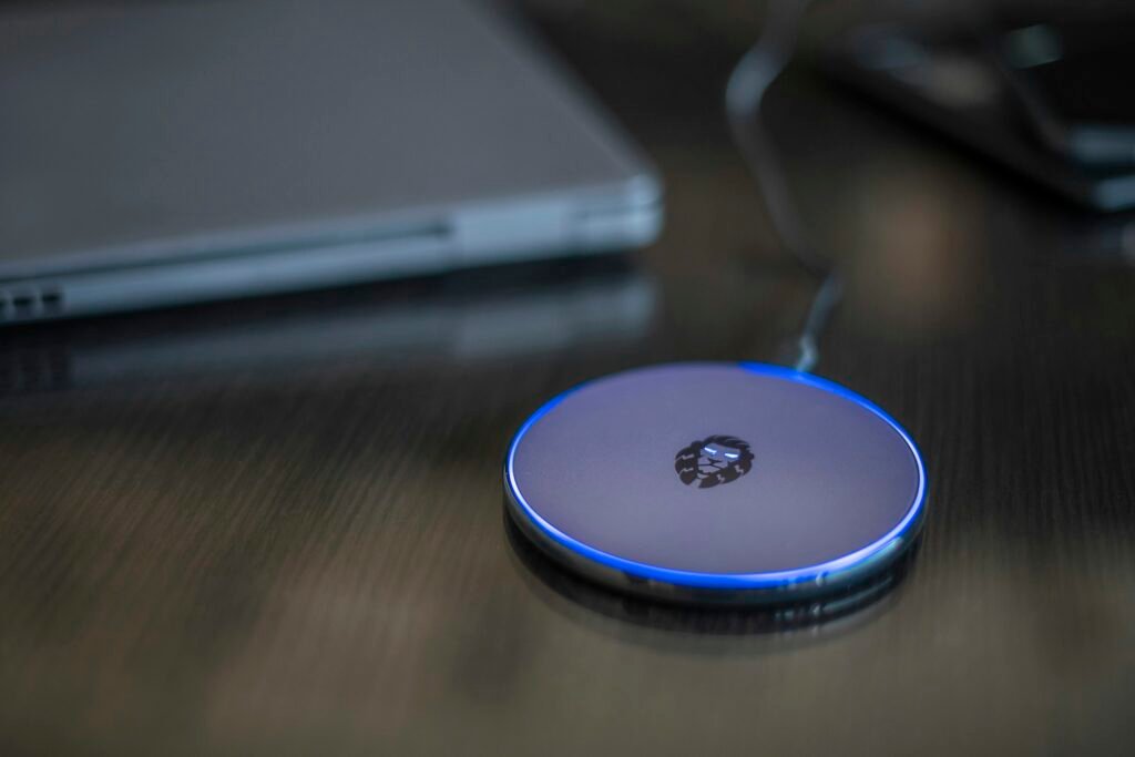 A smartphone resting on a wireless charging pad, illustrating 25W Qi2 wireless charging for the Pixel 11