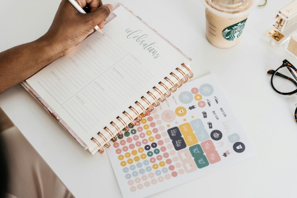 A person writing in a planner at a desk, illustrating scheduling meetings across three time zones in Google Calendar
