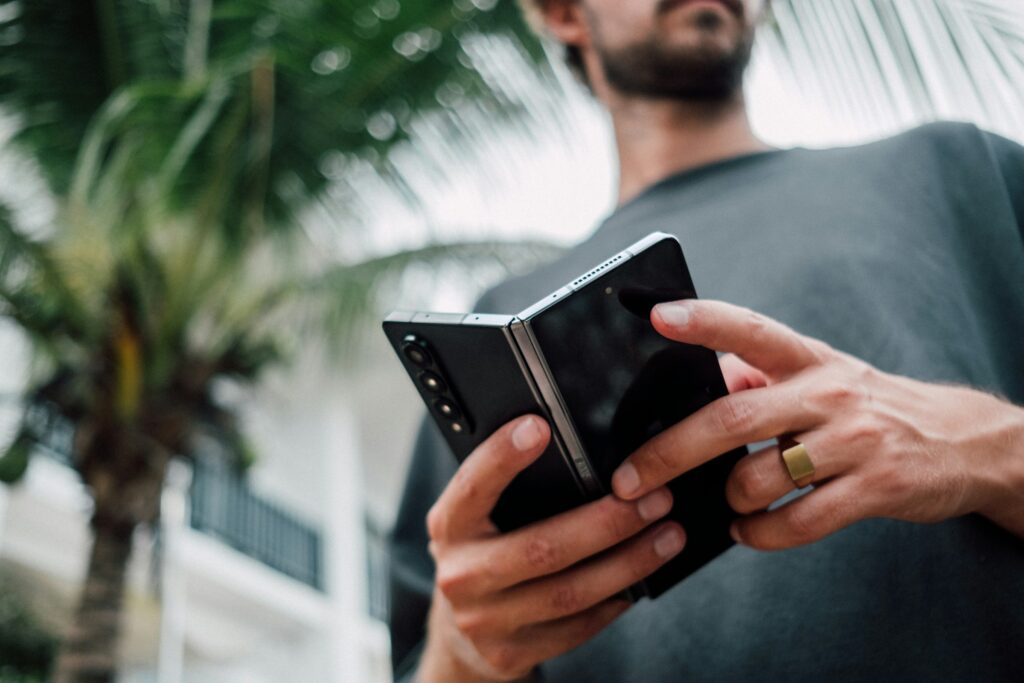 A man holding an unfolded Samsung Galaxy Z Fold, the book-style foldable line that now includes the Galaxy Z Fold 8