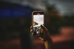 Person taking a photo with a smartphone, illustrating the new Redact and Moods editing tools in Google Photos for Android
