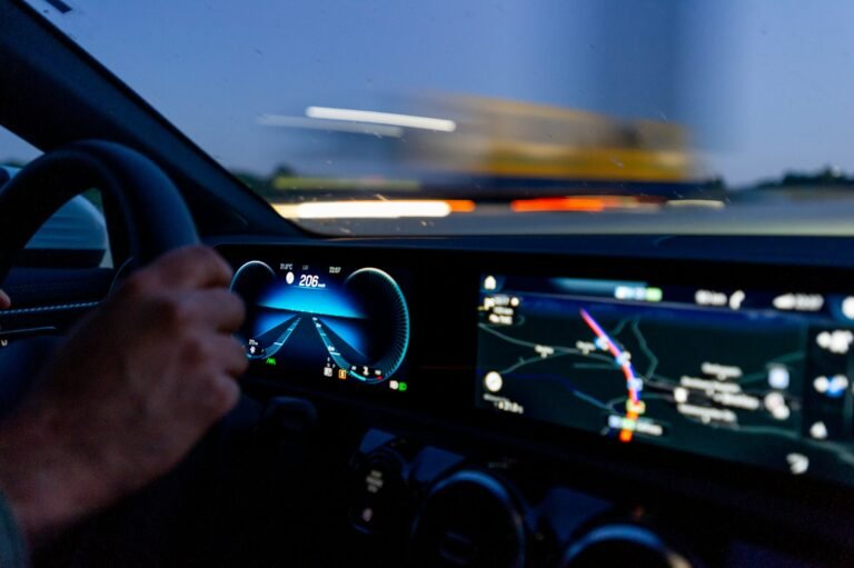 A driver's hand on a steering wheel, representing Gemini's troubled rollout on Android Auto