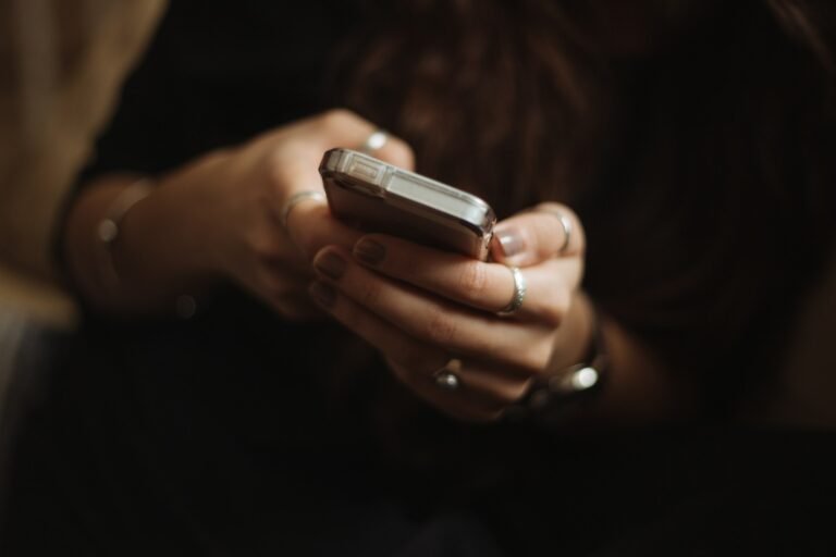 Person reading text messages on a smartphone, illustrating Google Messages' new long-press menu