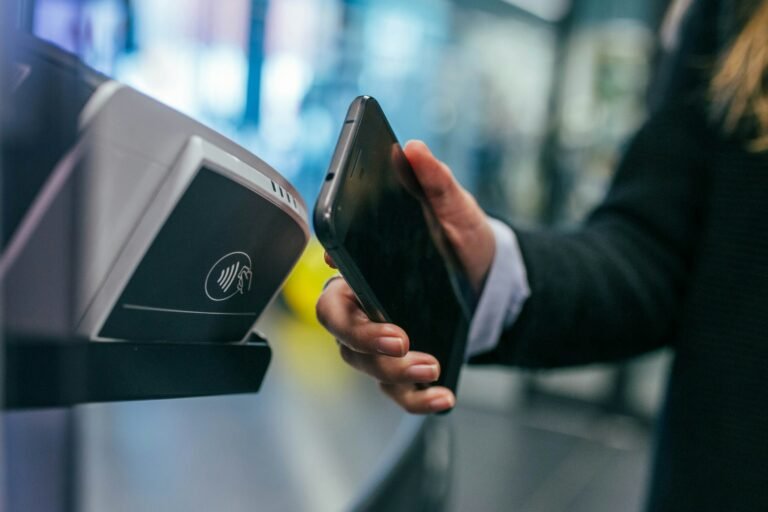 A phone held over a payment terminal for a contactless tap-to-pay purchase, as with Google Wallet