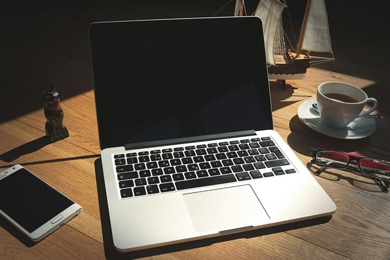 Laptop and smartphone side by side on a desk, the pairing Google's Googlebook laptops are built around