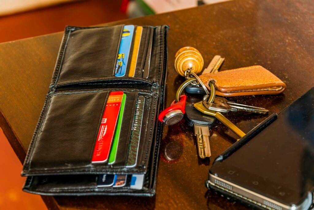 Keys, a wallet and a phone on a wooden table, the kind of everyday items Find Hub's Remembered tab can log