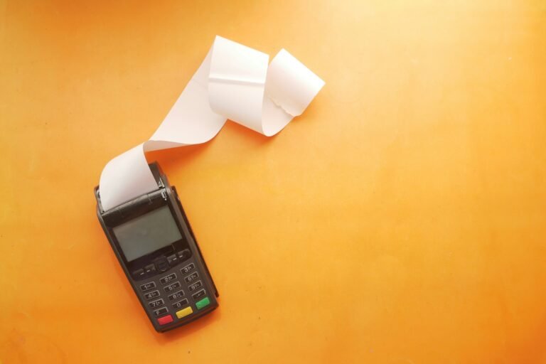 A card payment terminal printing a long paper receipt, the kind Google Wallet can now scan and store on Android