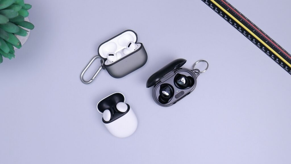 Wireless earbuds including Google Pixel Buds and their charging cases on a desk
