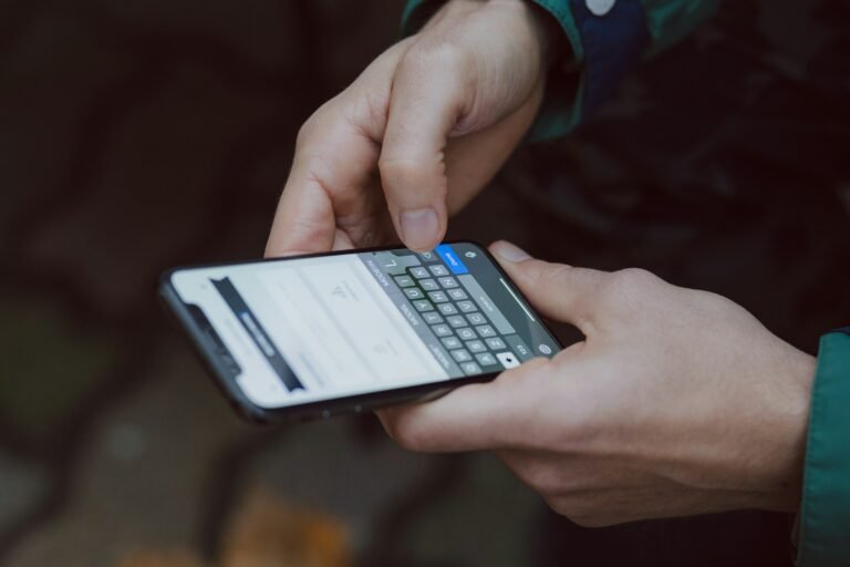 A person typing on a smartphone keyboard, illustrating the Gboard Shift key bug that blocks capital letters