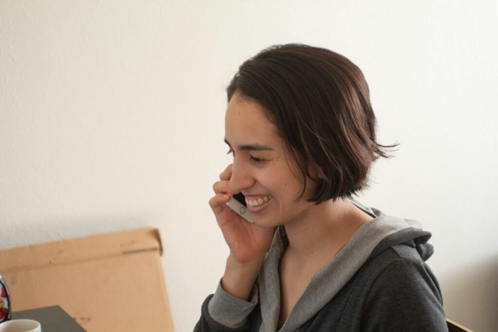 A woman working from home and talking into her phone, the hands-free style Gmail Live, Docs Live and Keep Live are built for
