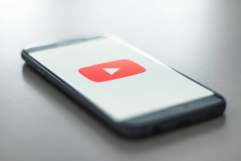 A smartphone showing the YouTube app, which is moving its Subscriptions feed from the bottom bar to the top of Home